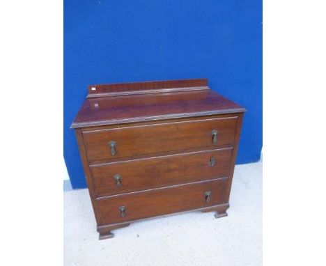 An Edwardian chest of three graduating drawers raised on shaped ogee bracket supports. 