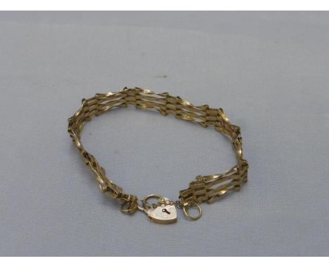 A 9ct gold gate bracelet with safety chain and lock. 