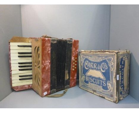 A Steldeni Delux accordion and a Carr & Co's Biscuits tin. 
