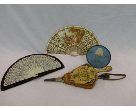 A hand decorated paper and ivory fan signed J. Serand, an ivory fan, a Folk Art decorated pair of bellows and a circular naut