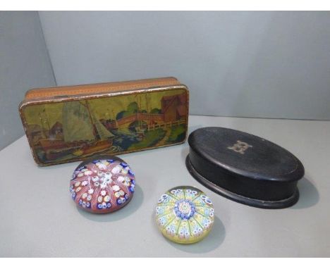 A collectors' tin depicting a Norfolk scene, an ebonised lidded trinket box and two millefiori glass paperweights. 