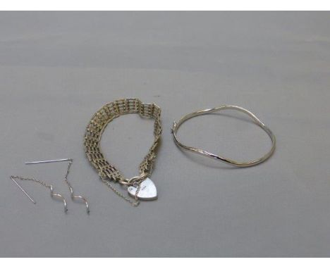 A 9ct white gold bangle and matching earrings and a silver gate bracelet. 