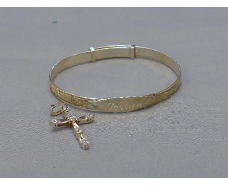 A silver christening bangle and a silver crucifix set with simulated diamonds. 