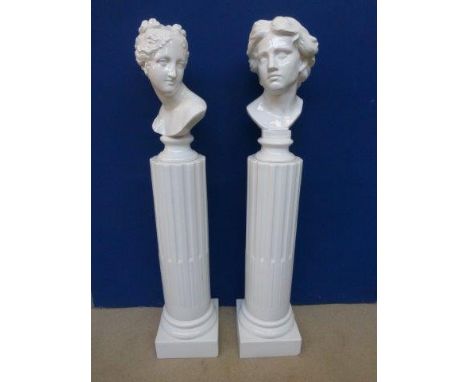 Two white ceramic busts mounted on Corinthium columns, one of a Grecian gentleman, the other a Grecian lady.  