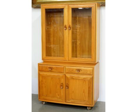 AN ERCOL SIDE CABINET, THE UNIT CLOSED BY GLAZED DOORS, 91CM W, 1970'S