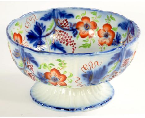 A BRITISH EARTHENWARE FOOTED BOWL, DECORATED IN FLOW BLUE, COPPER LUSTRE AND RED AND GREEN ENAMEL WITH STYLISED FLOWERS AND F