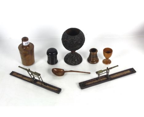 A collection of antique treen including a bottle case, "Go To Bed" egg cup, spoon, two 18th Century sovereign scales, carved 