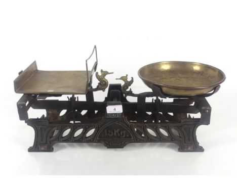 A set of vintage 15kg shop scales with brass pans and ornate bird figure indicators