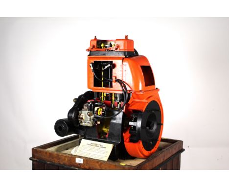 A Cutaway model of a Howard 810cc twin cylinder engine on wooden stand, powered via a electric drive motor housed below with 