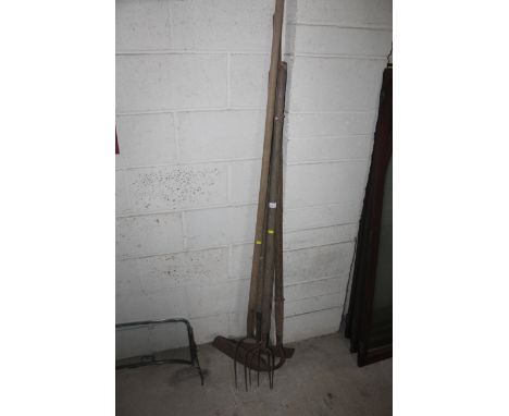 A quantity of long handled tools including pitch forks, scraper etc.
