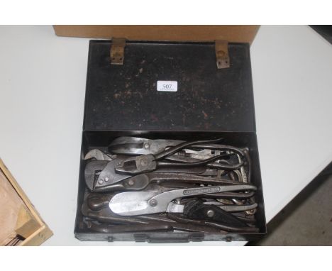 An ammunition tin containing a large quantity of metal vintage tools including snips, pliers, adjustable spanners etc. 