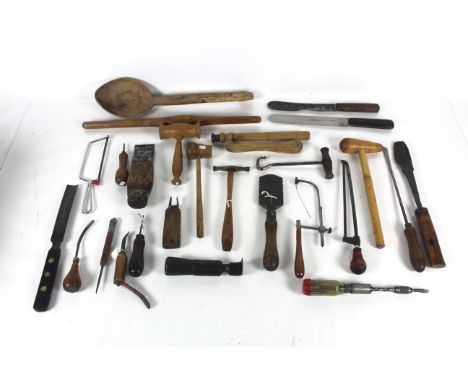 A box of tools to include peg splitter for tiles, a large wooden spoon, a hammer, knives etc.