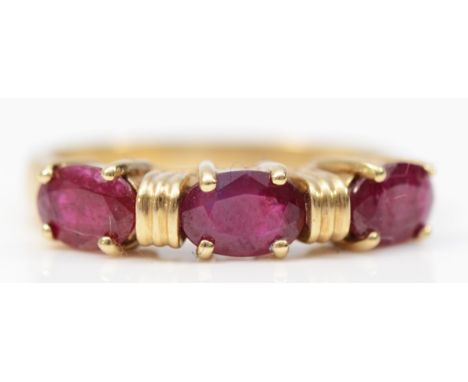 A 9ct gold oval cut ruby three stone ring, K 1/2, 2.5g 