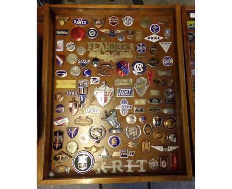 A good glazed case of mainly American enamel and other vehicle badges, to include: Stutz 8, Auburn, Flanders 20, Nash, Hudson