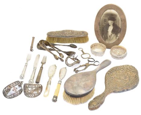 A selection of silver, to include silver sugar nips, silver backed mirror and brushes, a silver photo frame, white metal buck