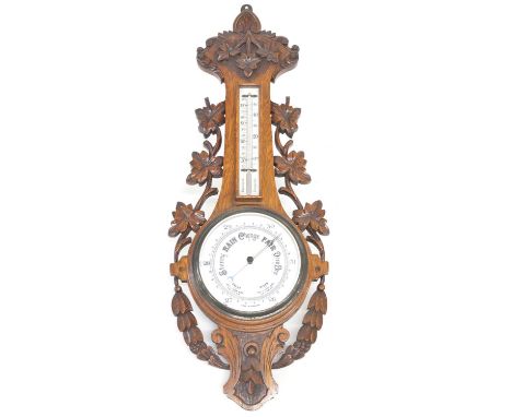 Aneroid barometer with enamel 19cm (8in) dial supported on carved oak case with a mercury thermometer,height 89cm (35in)Condi