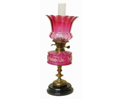 Victorian ruby glass oil lamp, red-tinted flared shade with clear glass chimney above matching reservoir decorated with trail