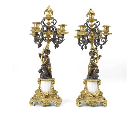 A pair of early 20th-century bronze and ormolu mounted four branch candelabra, each with central sconce, scrolling arms, cent