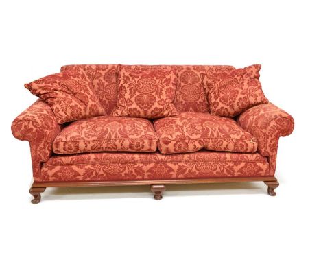 Edwardian mahogany framed sofa, sprung back and seat with scroll arms, two loose feather filled cushions, all standing on mah