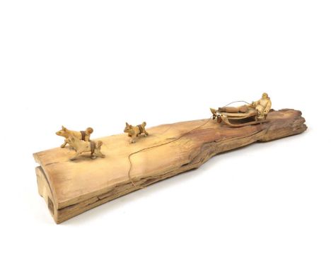 Early 20th-century Inuit carved marine bone figure depicting sled dogs and figure mounted on a splinter of bone.length 31cm (
