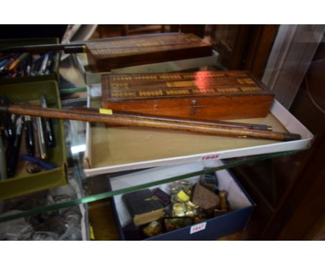 An antique mahogany and inlaid cribbage board, 27cm wide; together with a composite two part gun cleaning rod. 
