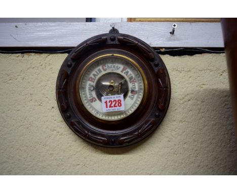 An old carved walnut aneroid circular barometer, 18cm diameter. 