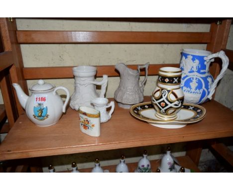 Four Victorian smear glazed jugs; together with another Victorian vase and stand; a Goss crested teapot; and another.  Condit