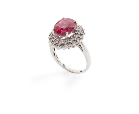 A tourmaline and diamond cluster ring claw-set with a reddish-pink oval-cut tourmaline, in a double border of round brilliant