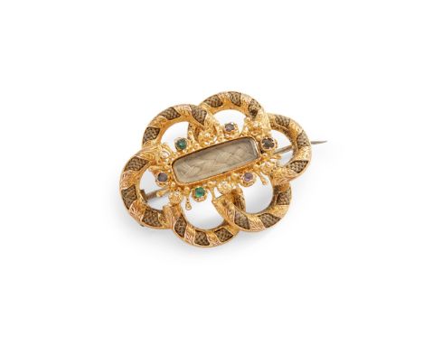 A mid 19th-century gem-set mourning brooch of open scrolling design, the glazed panel with plaited hair in a border of colour
