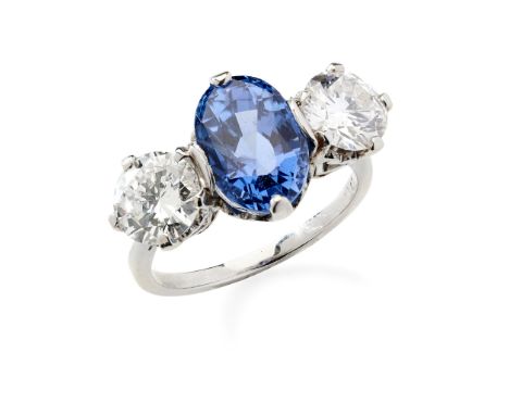 A sapphire and diamond three-stone ring claw-set with an oval-cut sapphire and two round brilliant-cut diamonds, the plain ba