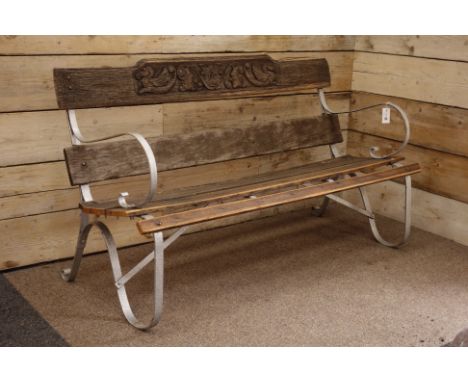 Silver painted bent metal and wood slatted bench, cresting rail carved with masks, scrolls and mythical beasts, W153cm, H91cm