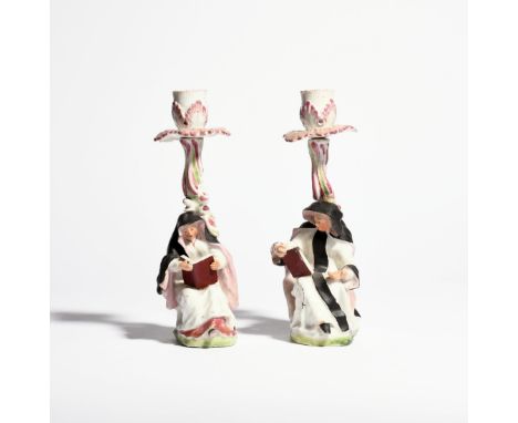 A rare pair of West Pans figural nun candlesticks c.1770, modelled as an Abbess and a Novice seated and reading from religiou