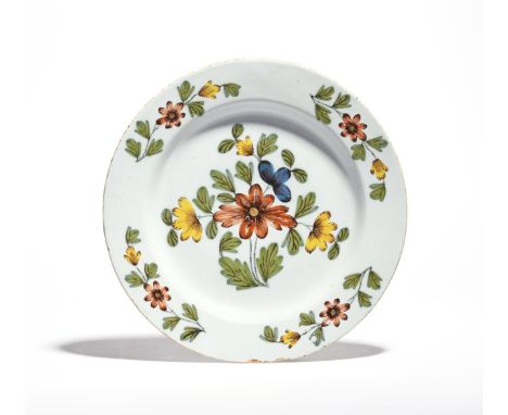 A Liverpool delftware large plate or charger   c.1760, painted in the Fazackerly palette with a bold flower spray, the rim wi
