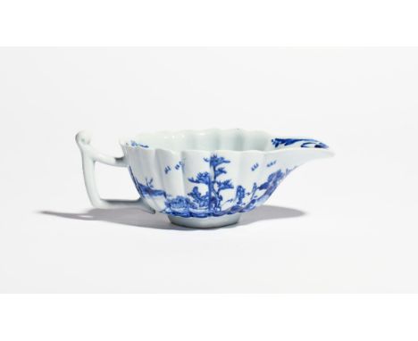 A Vauxhall small blue and white sauceboat c.1755-58, the wide fluted form painted with a continuous island landscape scene wi