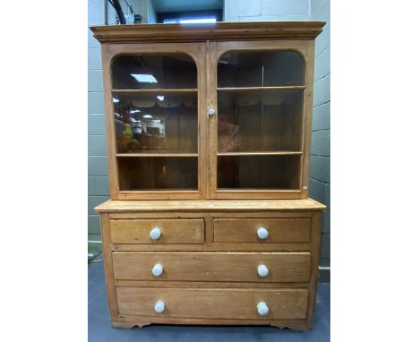 A Victorian pine glazed bookcasetwo arched cupboard doors enclosing shelves, the bottom section with two short over two long 