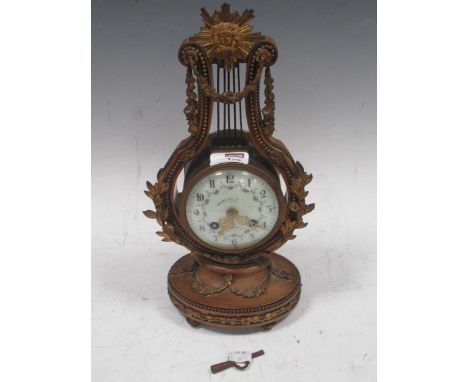 A late 19th century French gilt metal lyre shaped mantel clock,the lyre shaped case surmounted by sunburst medallion above fl