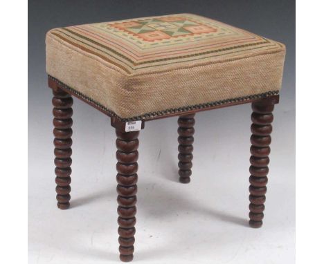A 20th century bobbin turned stool,the rectangular needlework seat decorated in a geometric pattern on tapered bobbin turned 