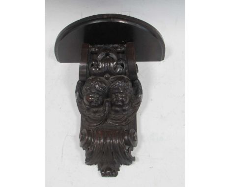 A 19th century carved corbel adapted with a shelf to form a decorative bracket carved with cherubs. 40cm x 33cm x 17cm projec