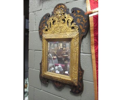 An early 20th century gilt and stained pine surround mirror, the bevelled edge plate with floral border and mask crest 82cm x
