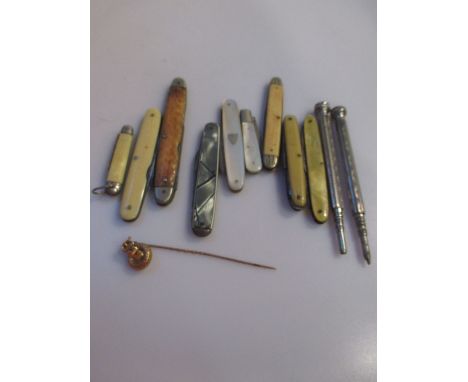 A collection of nine penknives together with three propelling pencils and a yellow metal 'belt and buckle' stick pin testing 