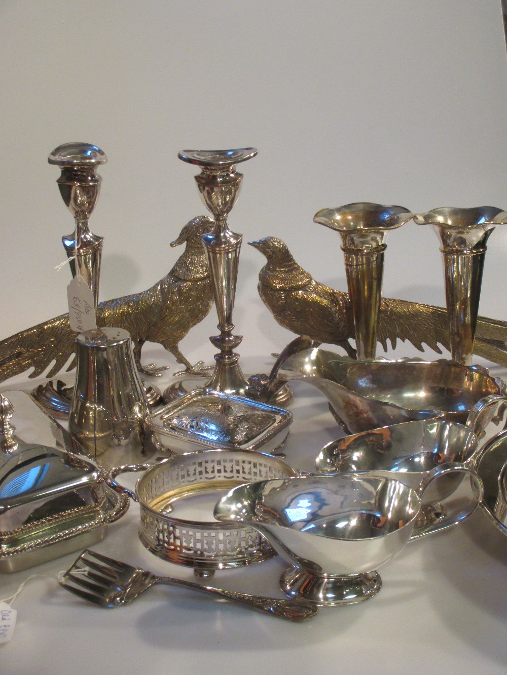 A collection of silver plated items including a pair of pheasants, a pair of candlesticks, vases