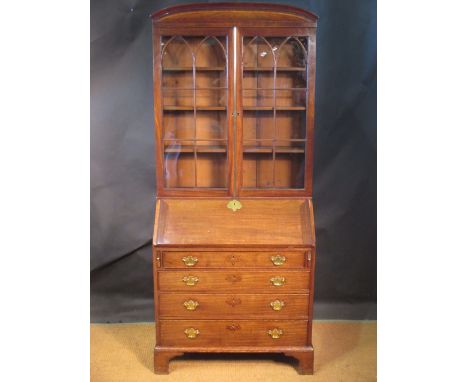 A George III mahogany bureau bookcase with pediment and gothic arched glazed doors, the fall front enclosing a fitted interio