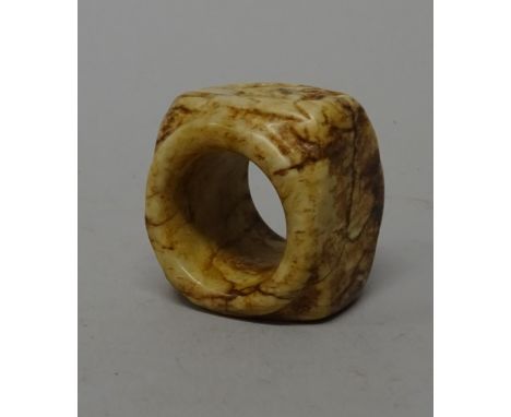 A Chinese cream and brown jade cong, probably 4th century B.C, rounded square form with tubular centre, carved on one side of