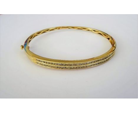 A gold and diamond set oval hinged bangle, mounted with two rows of small circular cut diamonds, on a snap clasp, detailed 14