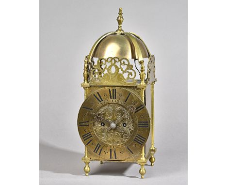 A BRASS QUARTER-STRIKING LANTERN CLOCKCirca 1910The case of typical form, surmounted by a bell and strapwork with turned fini