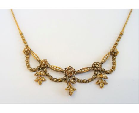 A gold and seed pearl fringe necklace, the front designed as a row of five flowerhead shaped clusters, connected by four pend