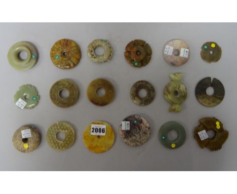 A group of fourteen Chinese archaistic jade bi discs, a jade split seal and three notched discs (xuanji), of various colours 