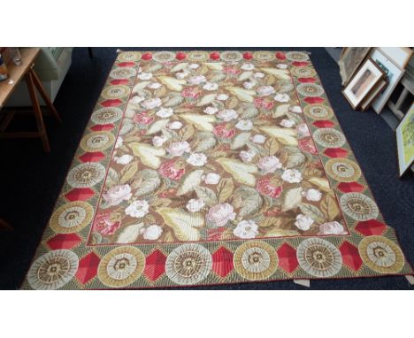 A tapestry carpet, the fawn field with an allover naturalistic design of roses and white blossom; a roundel and diamond borde