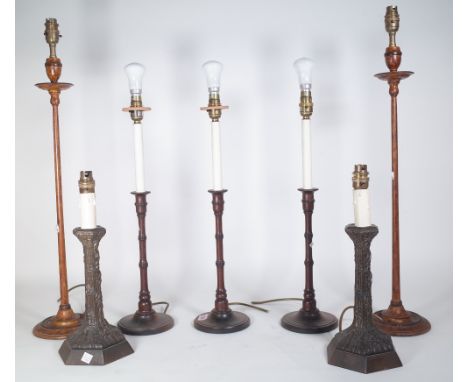 A set of three modern mahogany candlestick table lamps of turned form, 32cm high, a similar taller pair with square pleated s