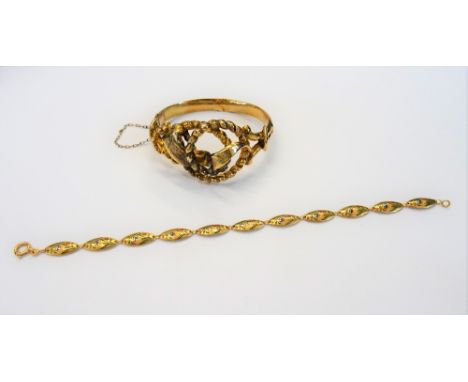 A gold oval hinged bangle, the front in an entwined design, on a snap clasp and a gold and enamelled bracelet, in an oval lin